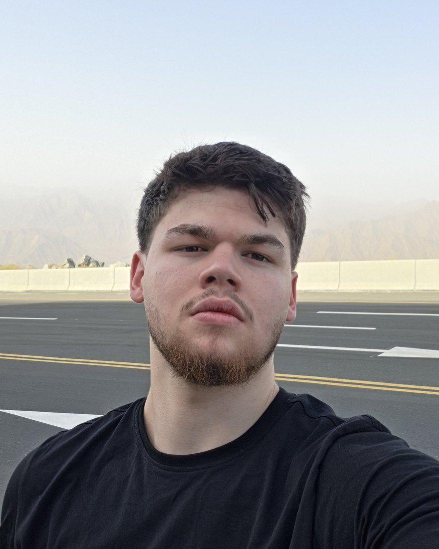 Younes Doughouz on a mountain road, with hazy peaks behind him